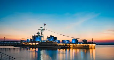 A naval warship at sea at sunset, representing defence cybersecurity contracts