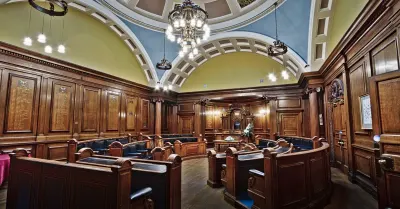 Empty local council committee chamber with rows of seats before a meeting, where council votes on planning applications take place