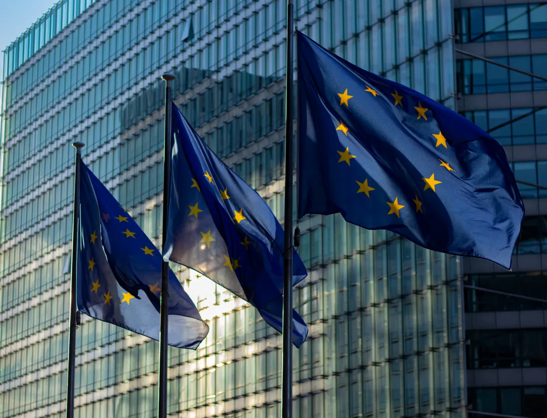 European Union flags outside the Berlaymont building in Brussels, where the Commission enforces Digital Services Act fines