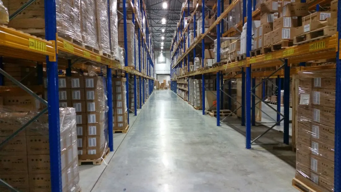 Long aisle of a distribution warehouse stacked with boxed goods, illustrating the logistics capabilities examined in the JD.com Ceconomy foreign subsidies regulation review