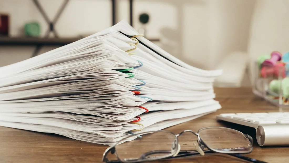 Thick stack of paper-clipped documents on a desk, representing the information requests at issue in China's blocking order against the EU foreign subsidies investigation