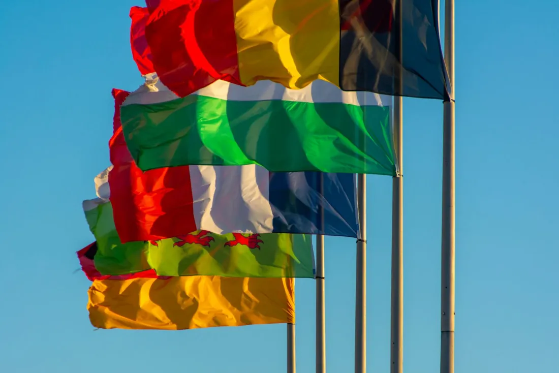 National flags flying on poles against a blue sky, illustrating whether arbitration awards can be enforced internationally