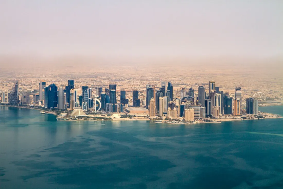 Aerial view of the Doha skyline on the waterfront, illustrating Qatar's domestic minimum top-up tax and global minimum tax rules
