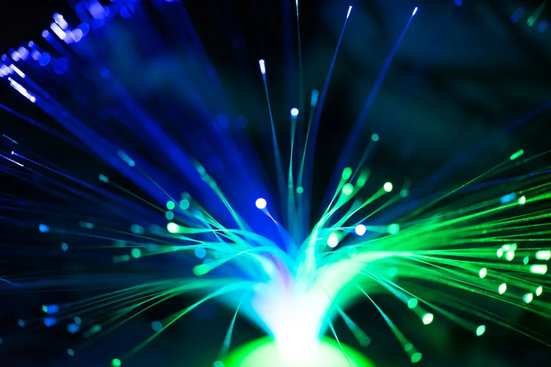 Glowing blue and green fibre optic strands, illustrating the streaming and video coding technology at issue in UPC patent litigation between InterDigital and Disney