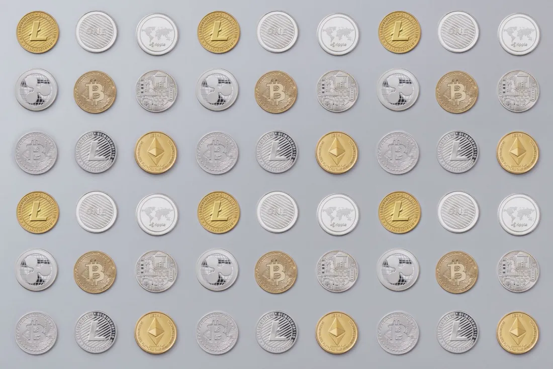 Rows of gold and silver cryptocurrency coins, illustrating whether crypto firms need FCA authorisation