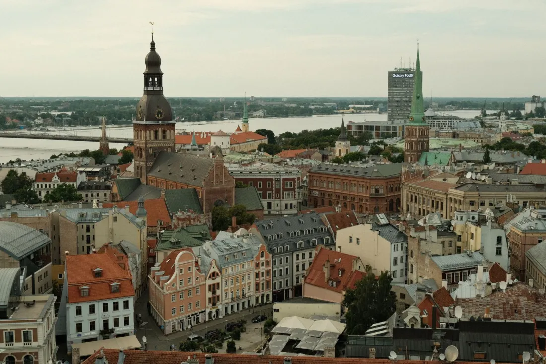 Aerial view of Riga Old Town rooftops and the Daugava river, illustrating whether you can get residency in Latvia if you buy a house