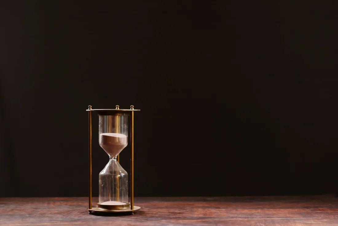 Hourglass on a wooden table, illustrating the EU AI Act timeline and the digital omnibus delay to high-risk rules