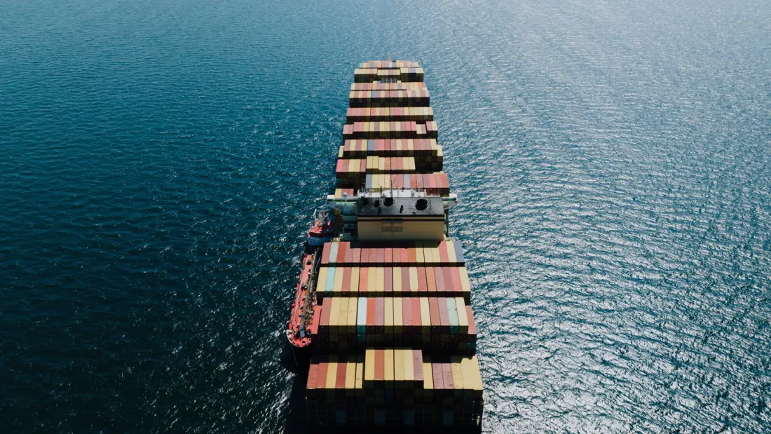 Aerial view of a loaded container ship at sea, illustrating the status of IEEPA refunds for importers