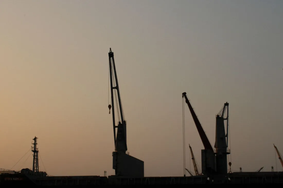 Silhouetted harbour cranes at dusk, illustrating the Section 301 and Section 122 tariffs that replaced the IEEPA tariffs