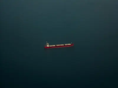 Aerial view of a lone cargo ship on open sea, illustrating what war risk insurance covers