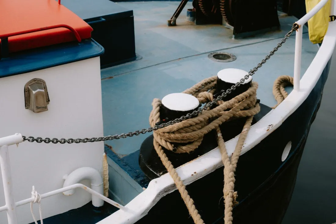 Mooring ropes and chain on a ship's bollards, representing charterparty war risk clauses and who pays the additional premium