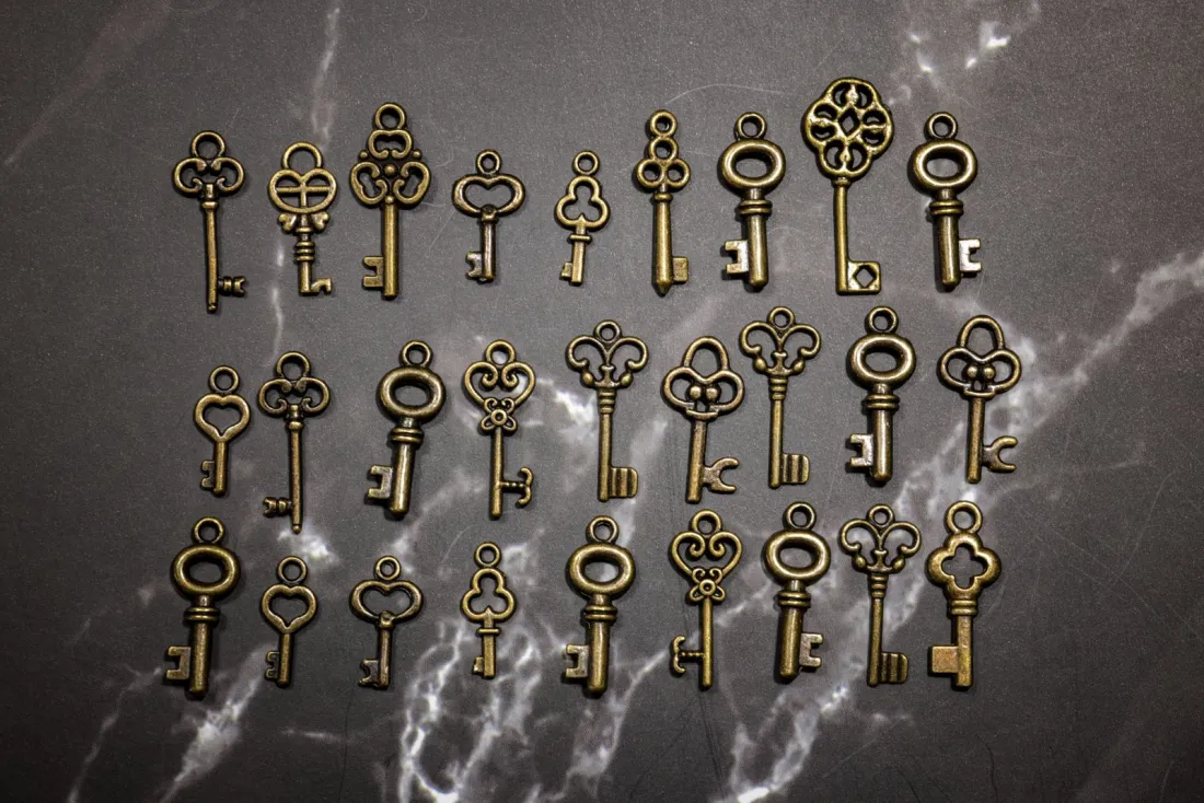 Antique brass keys arranged on dark marble, illustrating excluded property trusts after April 2025 and the long-term residence test for settlors