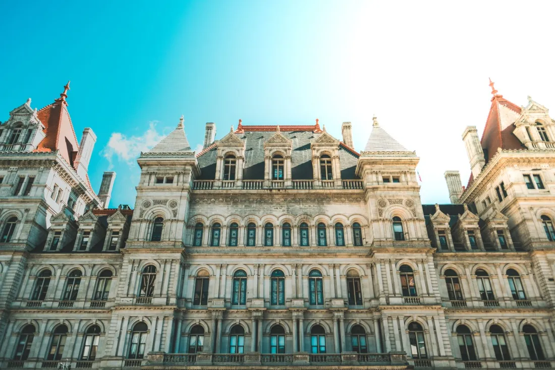 The New York State Capitol in Albany under a clear sky, where the 2026 New York auto tort reform was enacted through the state budget
