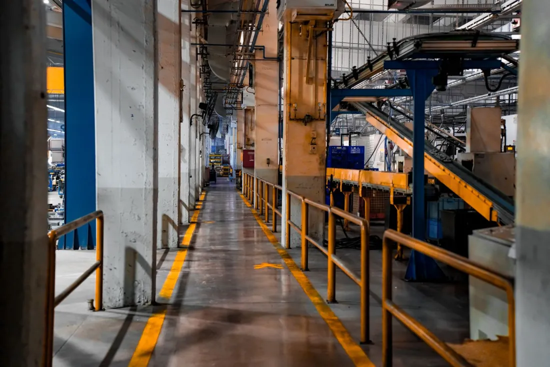 Empty walkway beside a conveyor line inside a large factory, illustrating the Fremont plant at the centre of the Tesla racial discrimination trial