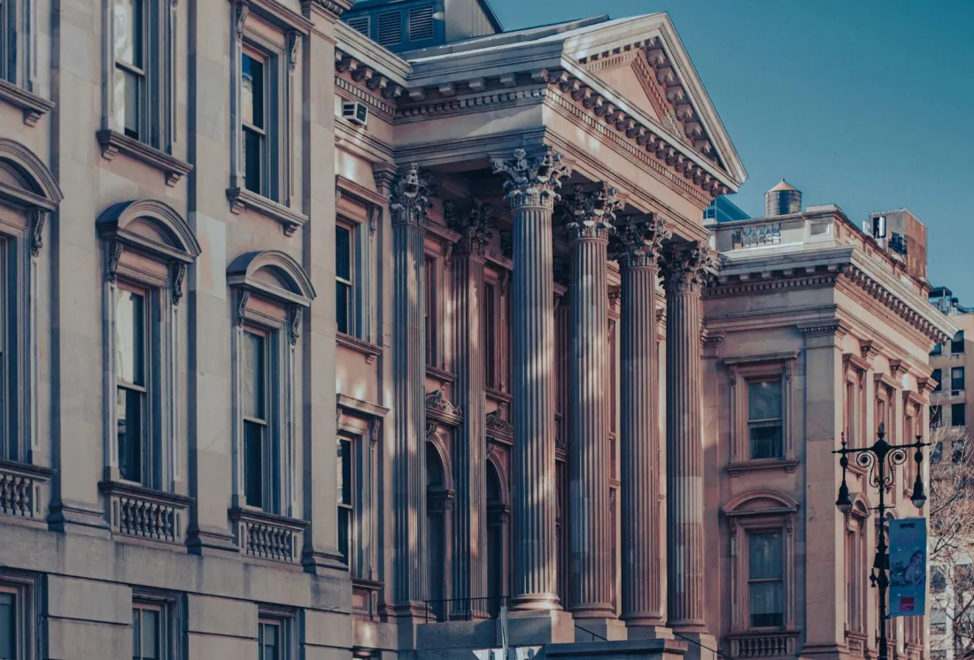 Neoclassical courthouse facade with tall columns at dusk, illustrating the FEHA damages cap question in the Tesla race discrimination lawsuit