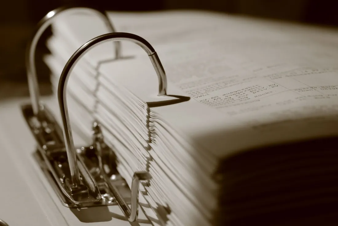 Close-up of a ring binder filled with loan documents, representing the promissory notes behind the fraud for which the former Nodus Bank CEO was sentenced
