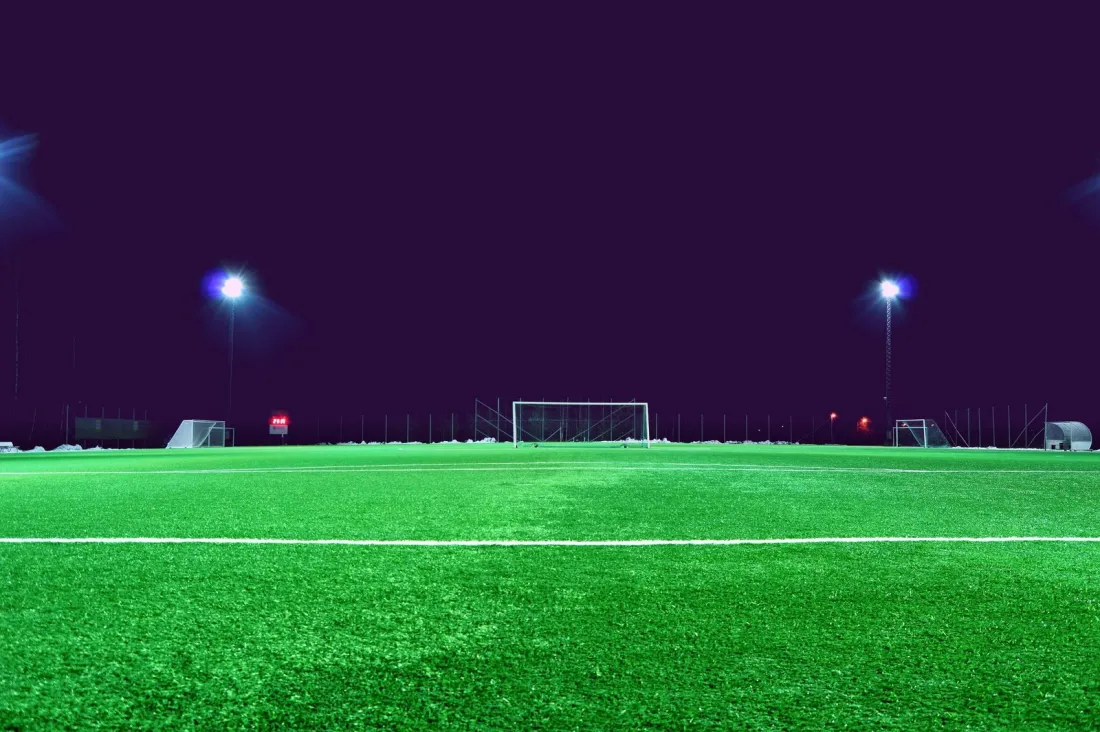 Floodlit empty football pitch at night, illustrating when Man City will be punished for the 115 charges