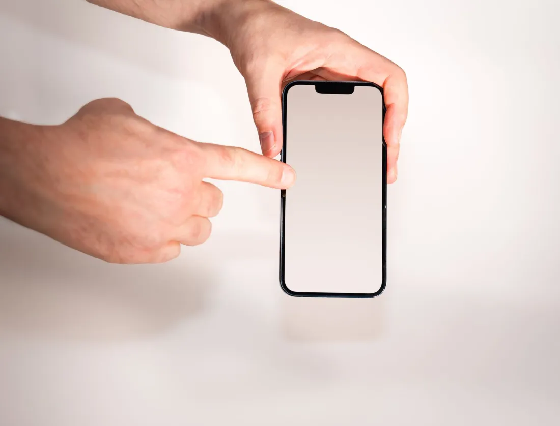 Finger touching the blank screen of a smartphone, illustrating the haptic feedback at the heart of the Taptic Engine patent case
