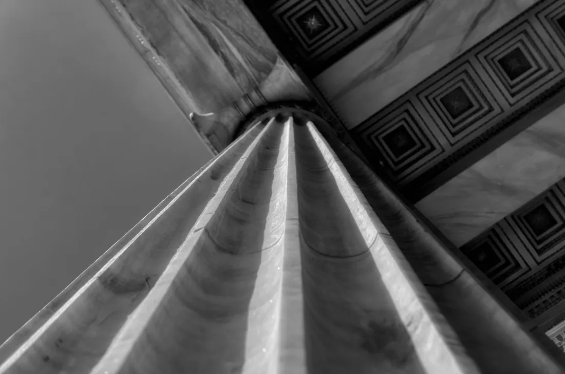 Low angle view of a fluted stone column in black and white, representing the Third Circuit appeal in Thomson Reuters v Ross on AI training and fair use