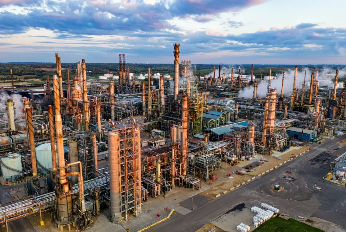 Aerial view of an oil refinery at sunset, illustrating whether oil companies can be sued for climate change