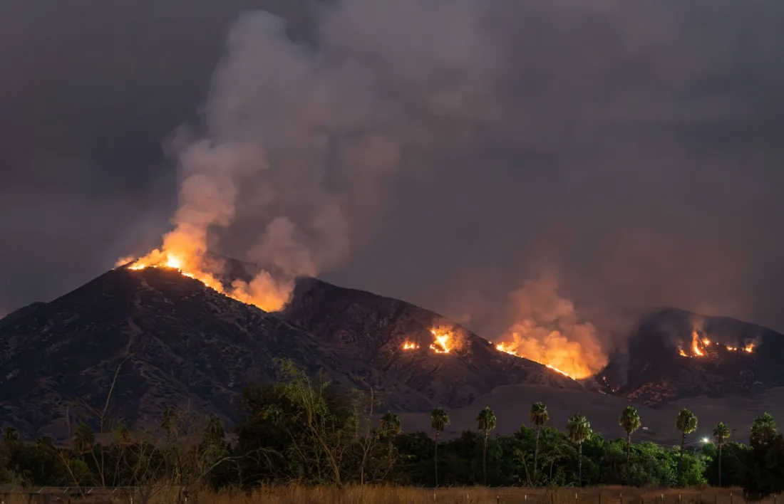 Wildfire burning across hillsides at night, the kind of climate harm at the centre of the question whether oil companies can be sued for climate change