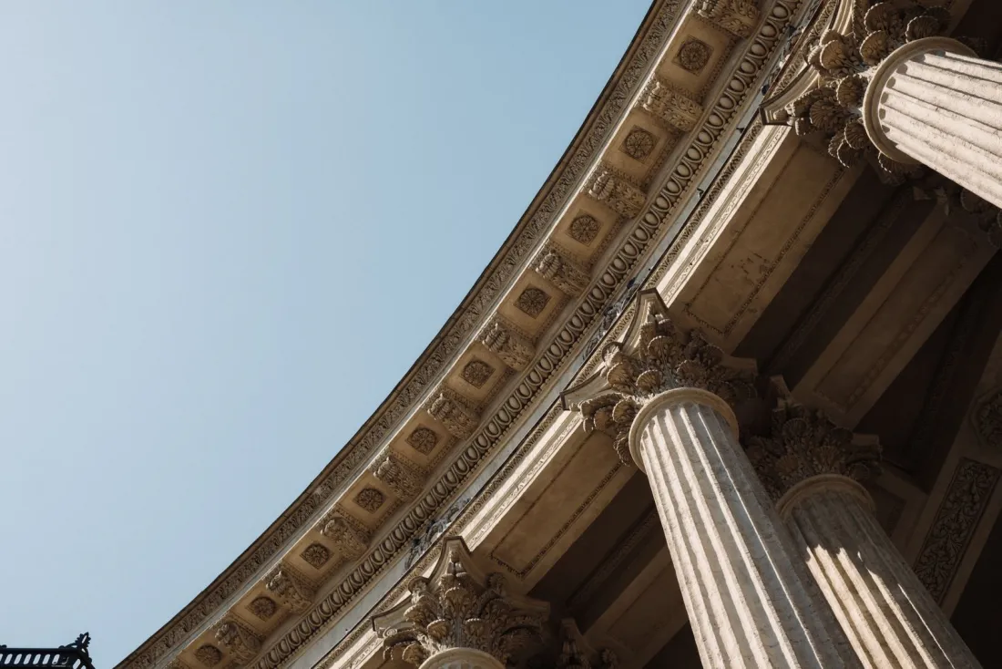 Classical courthouse columns seen from below, representing the Twitter v Taamneh aiding and abetting standard under the Anti-Terrorism Act