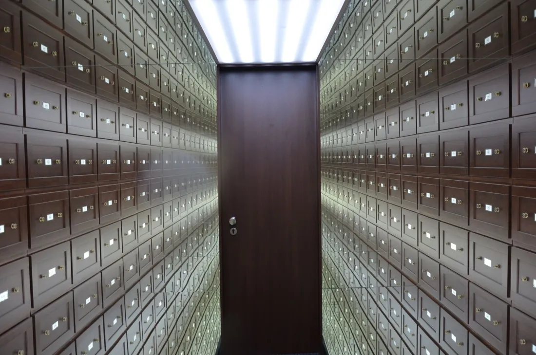 Corridor lined with safe deposit boxes, illustrating asset tracing and freezing injunctions in foreign judgment enforcement