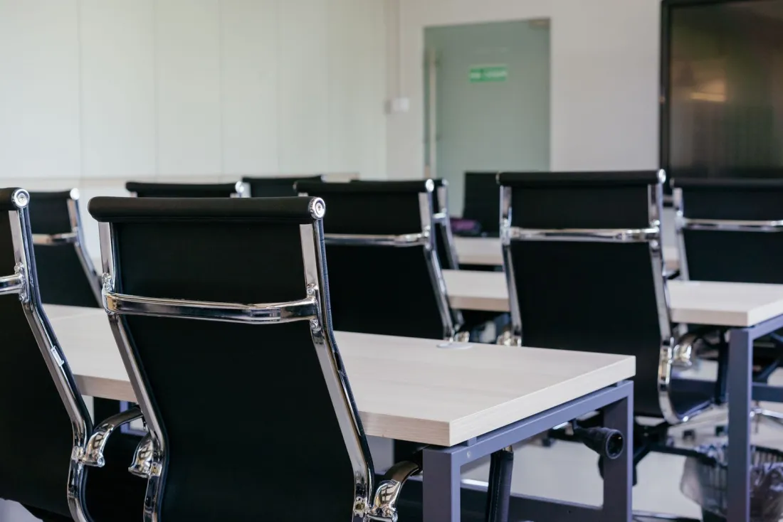 Empty meeting room with black office chairs, illustrating employer of record vs subsidiary choices for first hires abroad