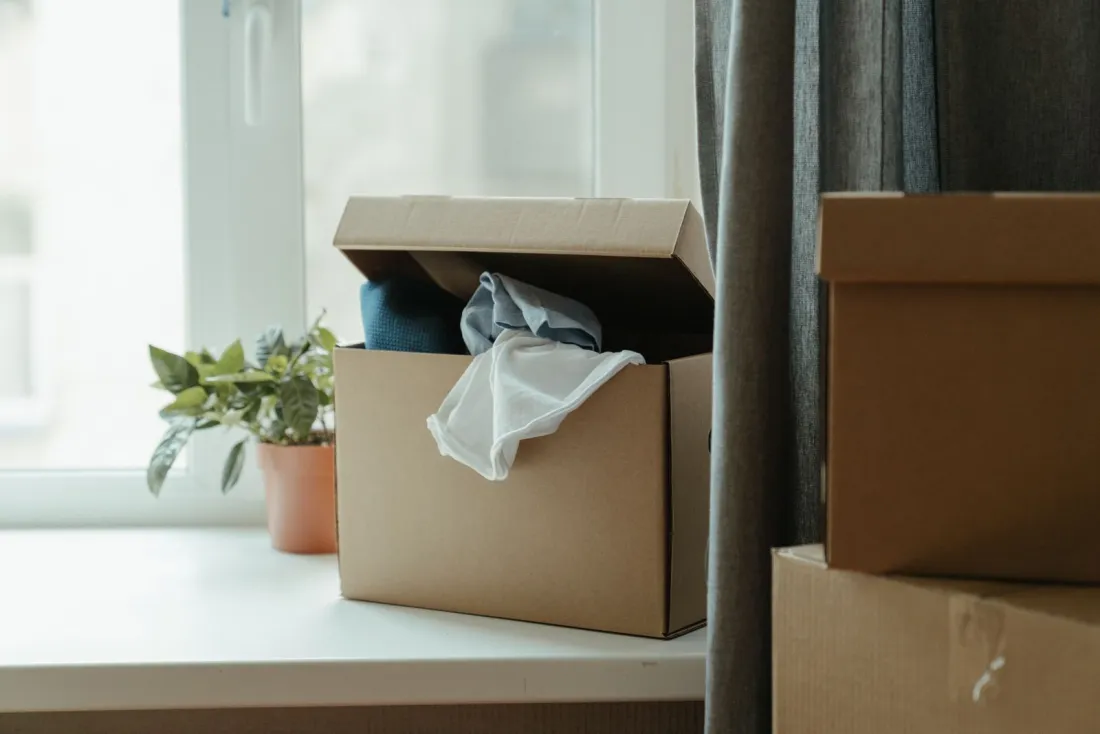 Packed cardboard boxes by a window, illustrating exit planning when you become non resident for UK tax