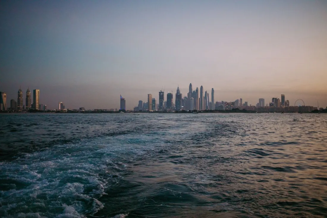 Dubai Marina skyline at dusk seen from the sea, illustrating UAE tax residency for people moving from the UK