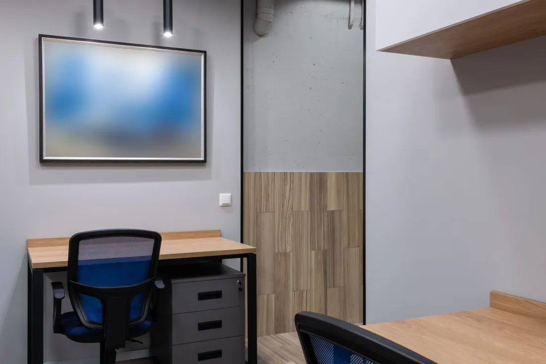 Small modern office with two empty desks and blue chairs, illustrating the HR systems a business needs to keep a sponsor licence