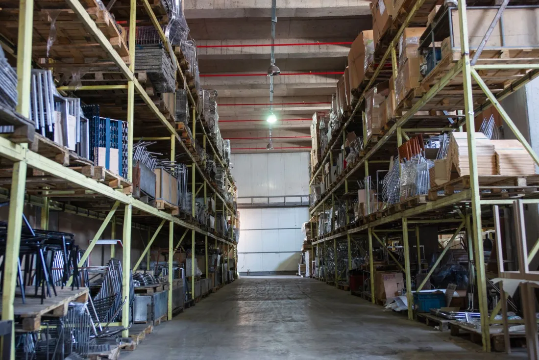 Warehouse aisle lined with stocked shelving, representing supplier goods and retention of title claims when a customer goes into administration