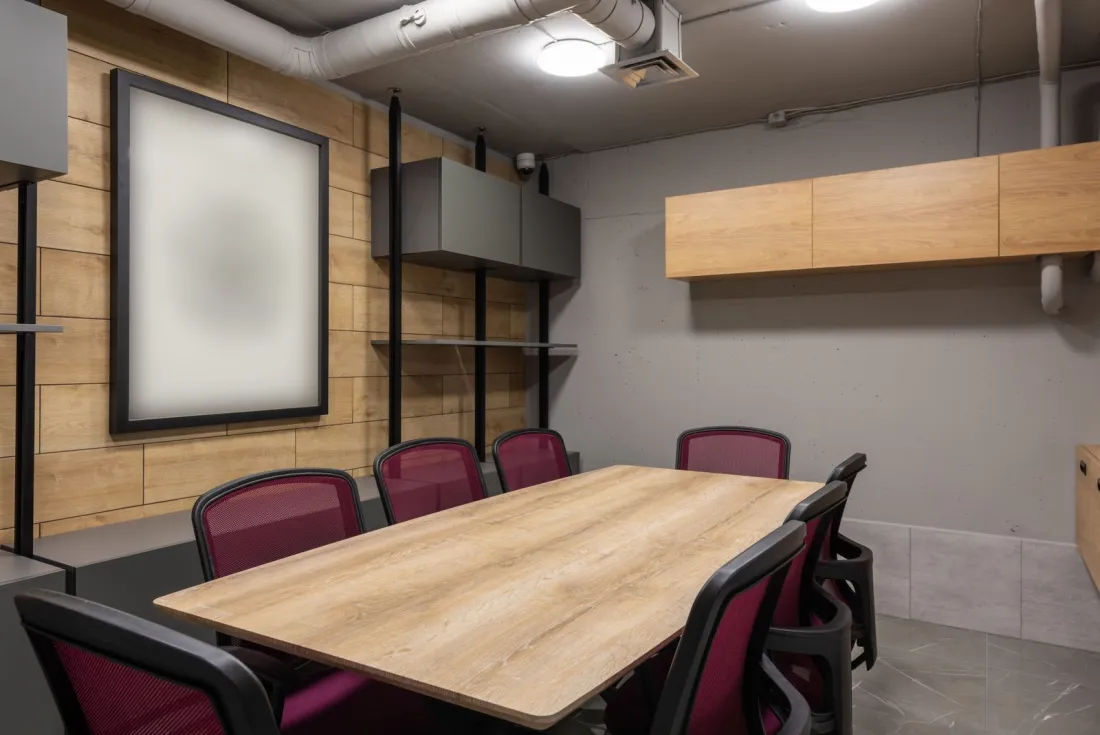 Empty boardroom with a wooden table and red chairs, illustrating what happens to directors when a company goes into administration