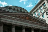 Carved neoclassical bank facade with stone columns under a blue sky, illustrating why Bank of America was fined $1.21 billion for AML and sanctions failures