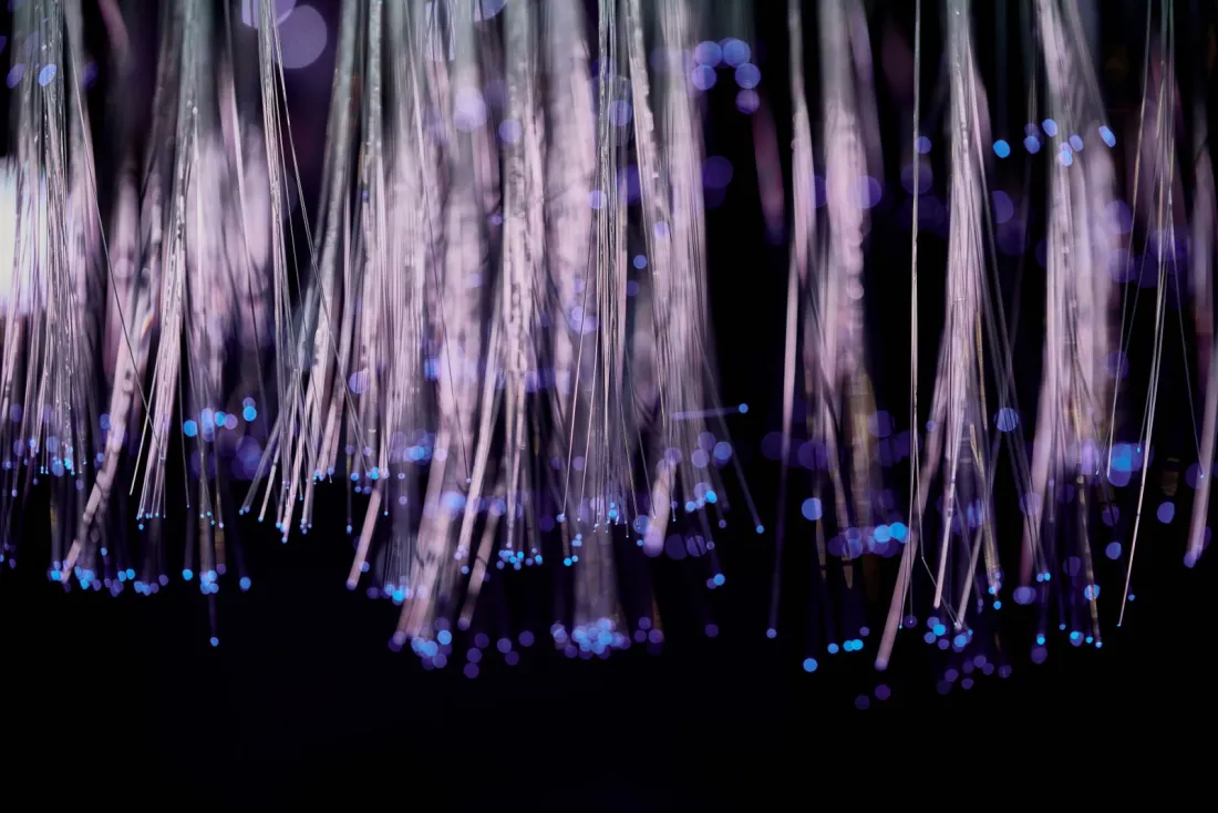 Strands of fibre optic light against a dark background, illustrating the transaction monitoring failures behind Bank of America's money laundering fine