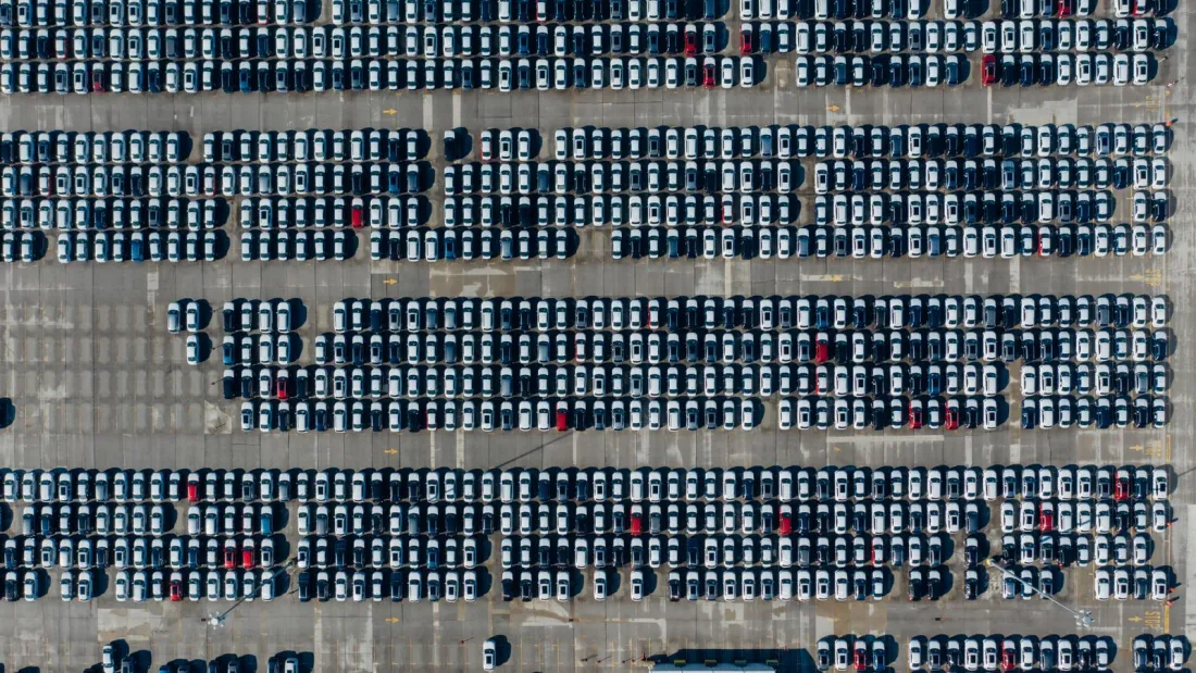 Aerial view of long rows of parked vehicles in a storage lot, illustrating the auto auction customers in the Bank of America consent order