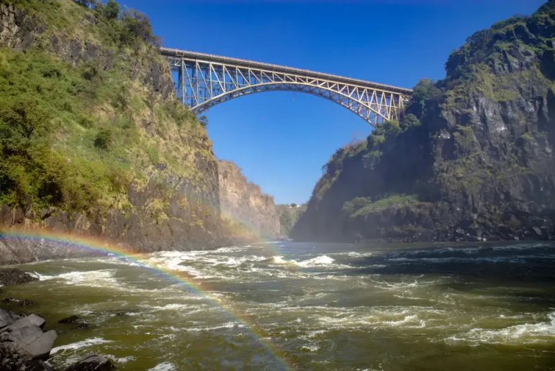 Victoria Falls Bridge over the Zambezi gorge with a rainbow in the spray, on the Zambia–Zimbabwe border: lawyers and advisers in Zambia