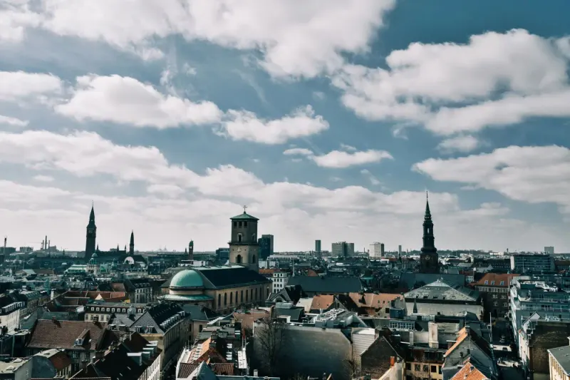 Rooftops and church spires of central Copenhagen under a blue sky, Denmark: lawyers and advisers in Denmark