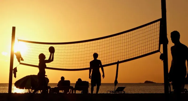 Silhouettes playing beach volleyball at sunset on a beach in Antigua: lawyers and advisers in Antigua and Barbuda