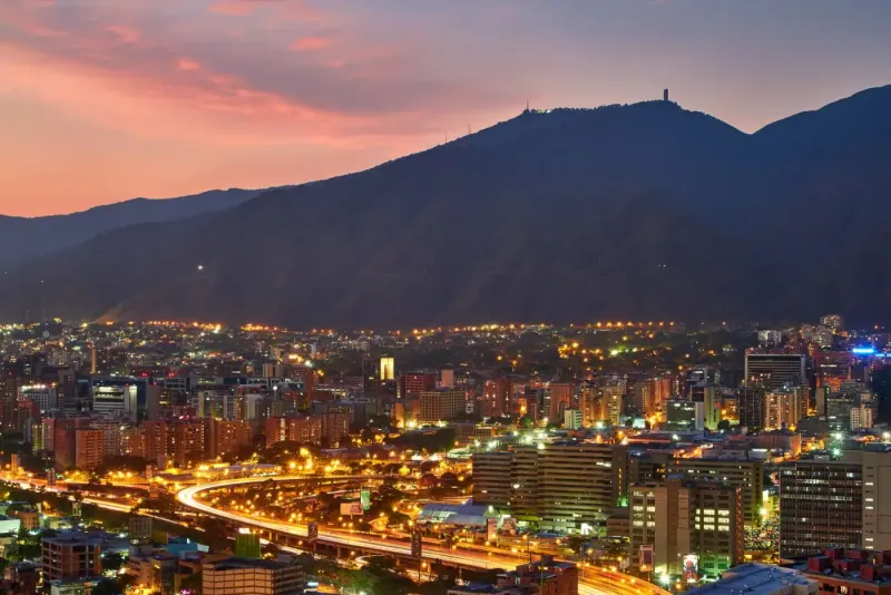 Caracas city lights at dusk below the Ávila mountain, Venezuela: lawyers and advisers in Venezuela