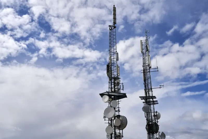 Telecommunication towers with antennas and dishes under a cloudy sky: technology, media & telecoms lawyers and advisers