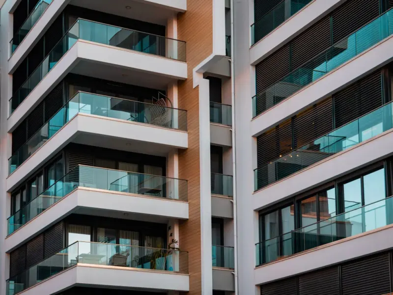 Modern apartment building with glass balconies: real estate & property lawyers and advisers