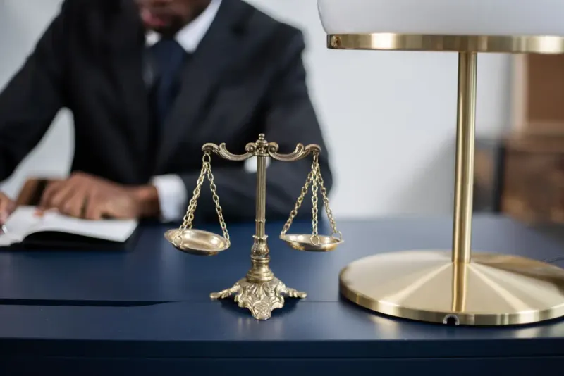 Brass scales of justice on a dark desk in a legal office: competition & antitrust news and analysis