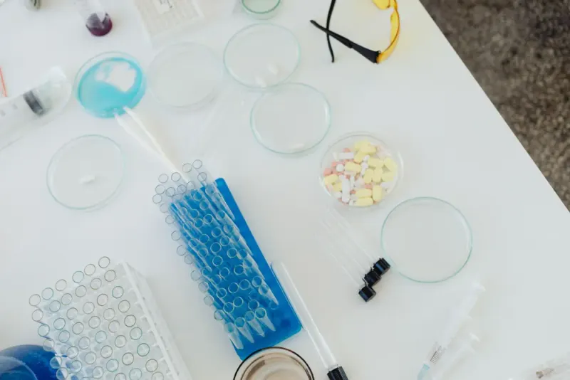Overhead view of laboratory petri dishes, test tubes, pills and syringes: life sciences & pharmaceuticals news and analysis
