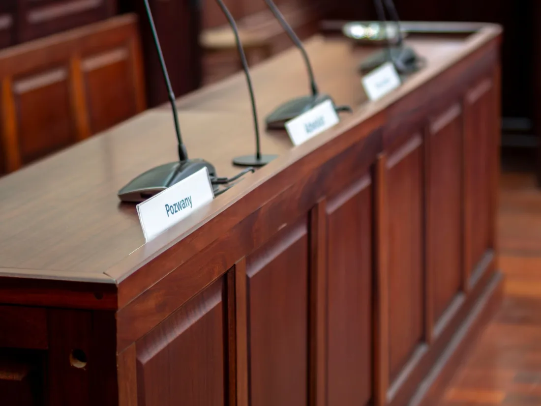Counsel's bench with microphones in a courtroom, where fake case citations from AI tools can lead to personal costs orders