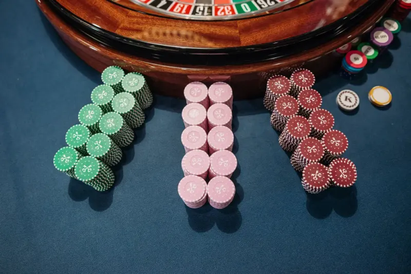 Stacks of casino chips beside a roulette wheel: gaming lawyers and advisers