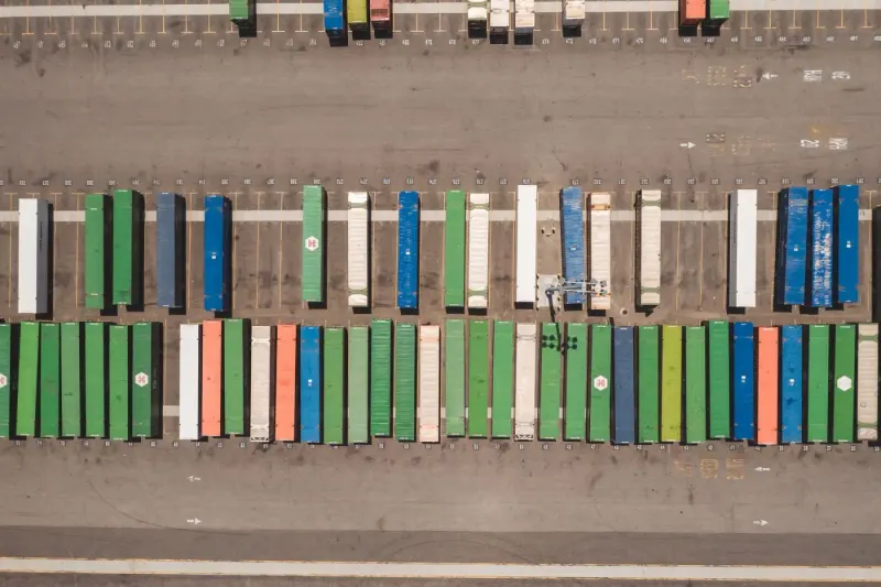 Aerial view of rows of cargo containers in a logistics yard: export control lawyers and advisers