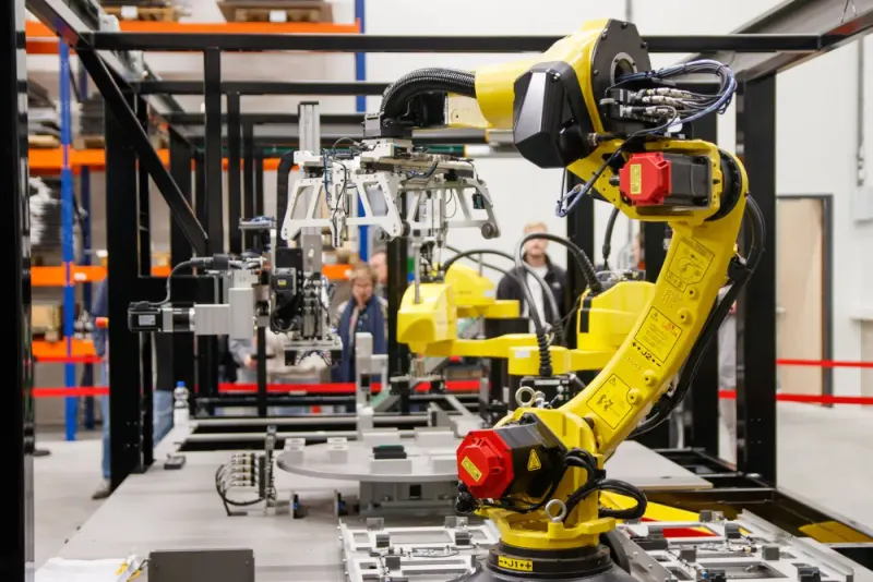 Yellow industrial robotic arm in a manufacturing facility: manufacturing experts and advisers