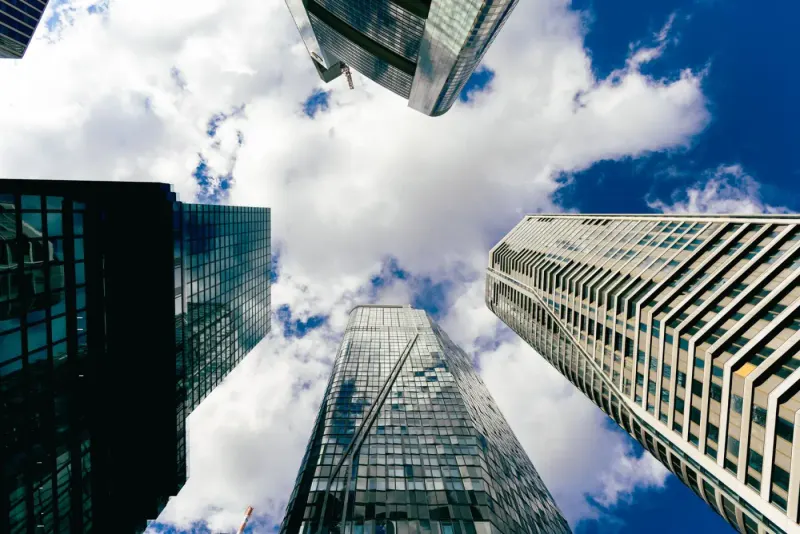 Looking up at Frankfurt skyscrapers against a cloudy blue sky: private funds experts and advisers