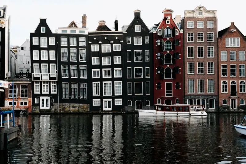 Historic canal houses reflected in a canal, Amsterdam, Netherlands: lawyers and advisers in the Netherlands